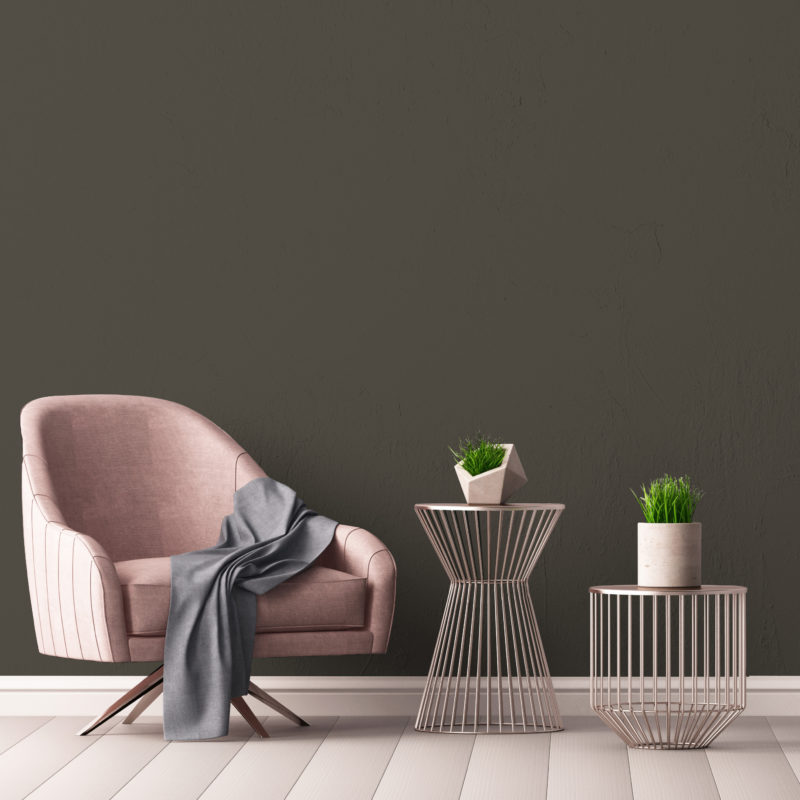 Interior with an armchair and a little table on a background of